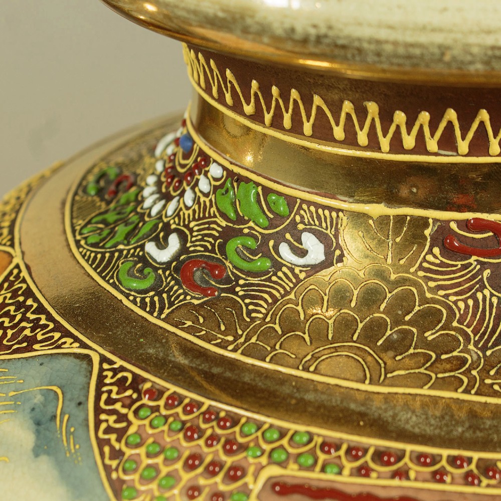 A pair of large Japanese Satsuma earthenware vases featuring hand-painted enamelled figures and high-relief gilded dragons wrapped around the necks. View VII