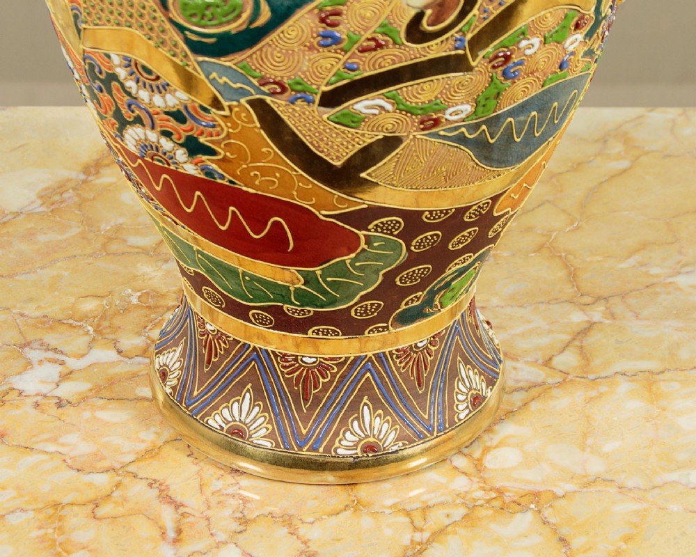 A pair of large Japanese Satsuma earthenware vases featuring hand-painted enamelled figures and high-relief gilded dragons wrapped around the necks. View XII