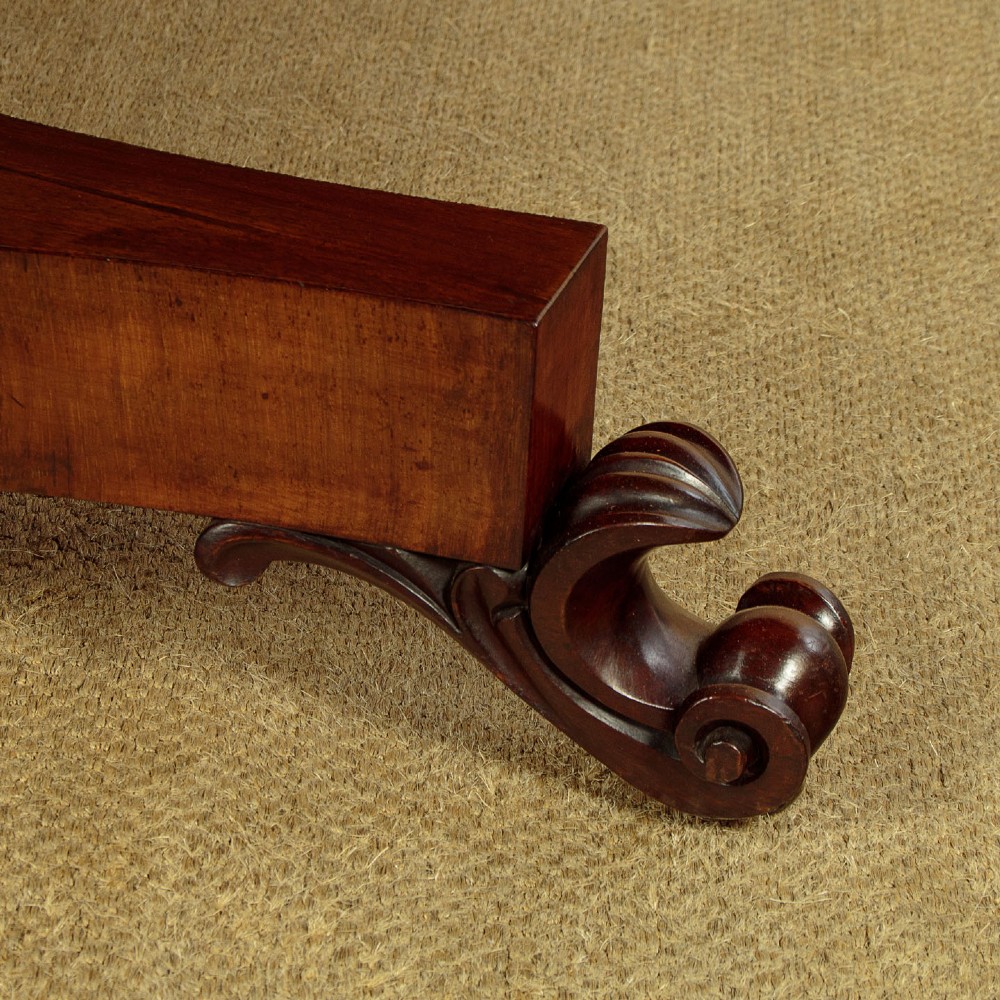 An oval Victorian mahogany library table featuring a green gilt-tooled leather top, frieze drawers, and a central pedestal with carved scroll feet on castors. View XI