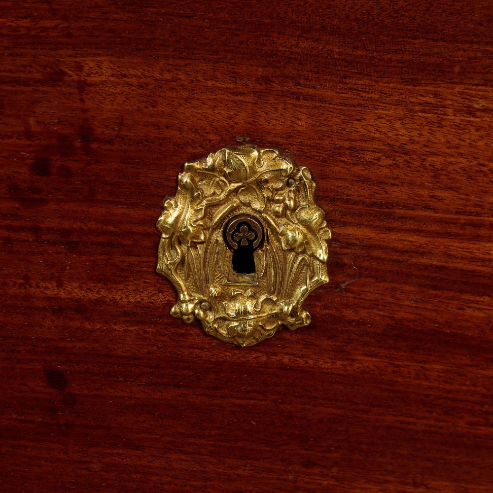 A French Empire mahogany commode featuring three long drawers, brass lion mask ring handles, carved claw feet, and a dark grey marble top. View XII