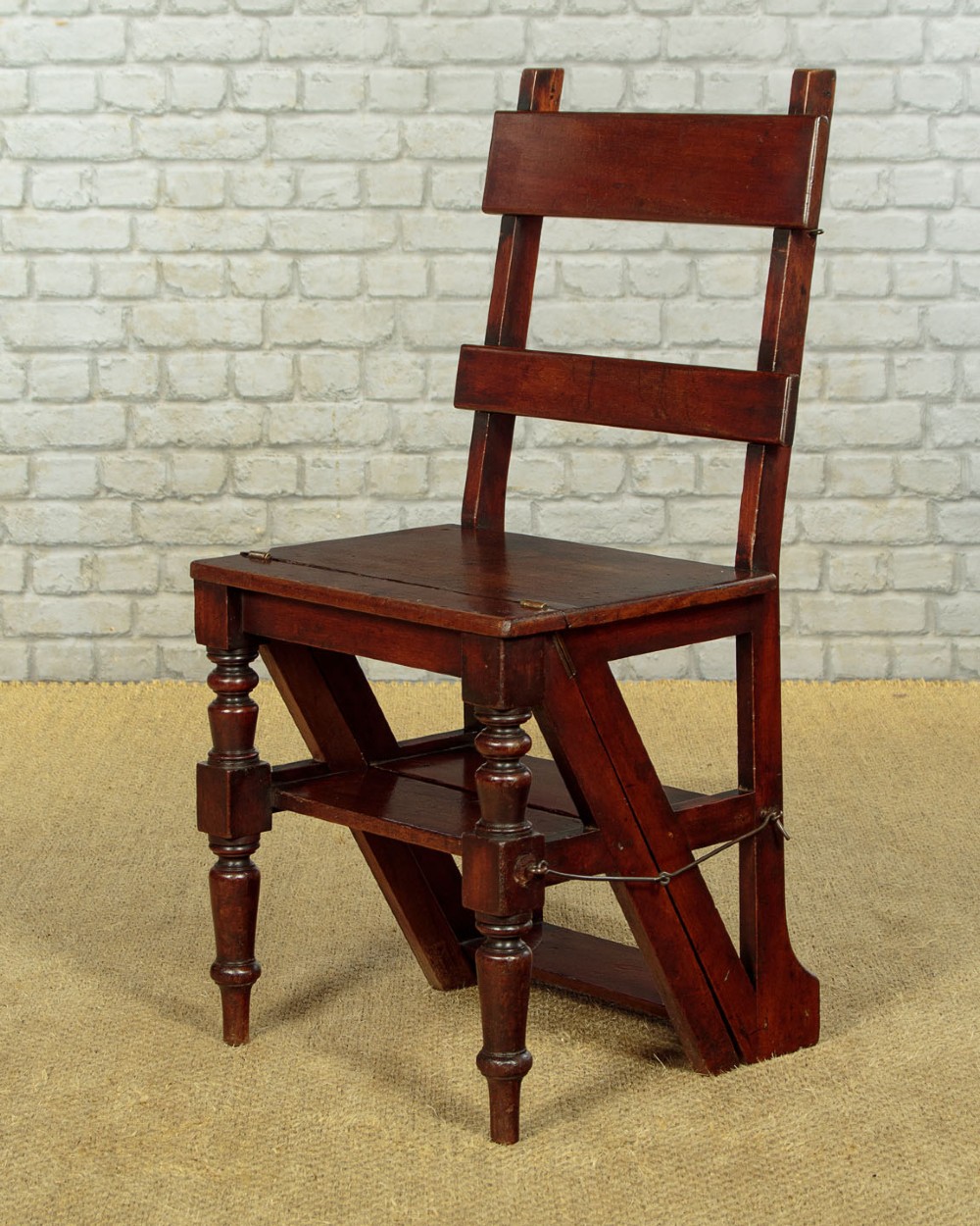 A late Victorian metamorphic mahogany side chair with turned front legs that folds open to convert into a short flight of library steps.