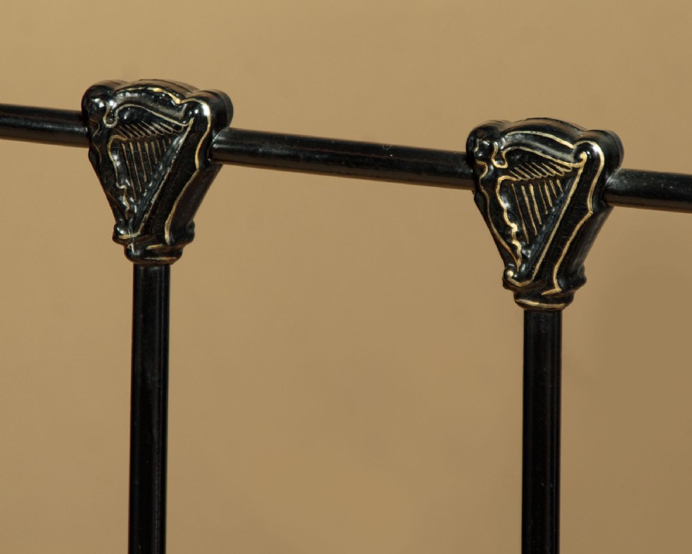 A late Victorian black iron and brass king-size bed frame featuring decorative brass finials, a dipped brass top rail, and vertical spindles. View IX