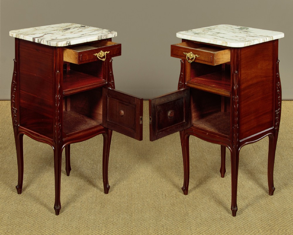 A pair of late 19th-century mahogany bedside cabinets featuring variegated marble tops, single upper drawers, open shelf recesses, and lower cupboards supported on cabriole legs. View II