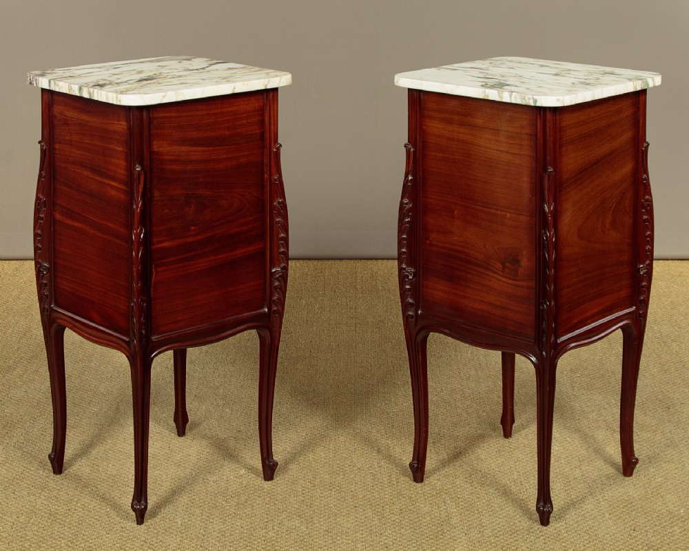 A pair of late 19th-century mahogany bedside cabinets featuring variegated marble tops, single upper drawers, open shelf recesses, and lower cupboards supported on cabriole legs. View XI