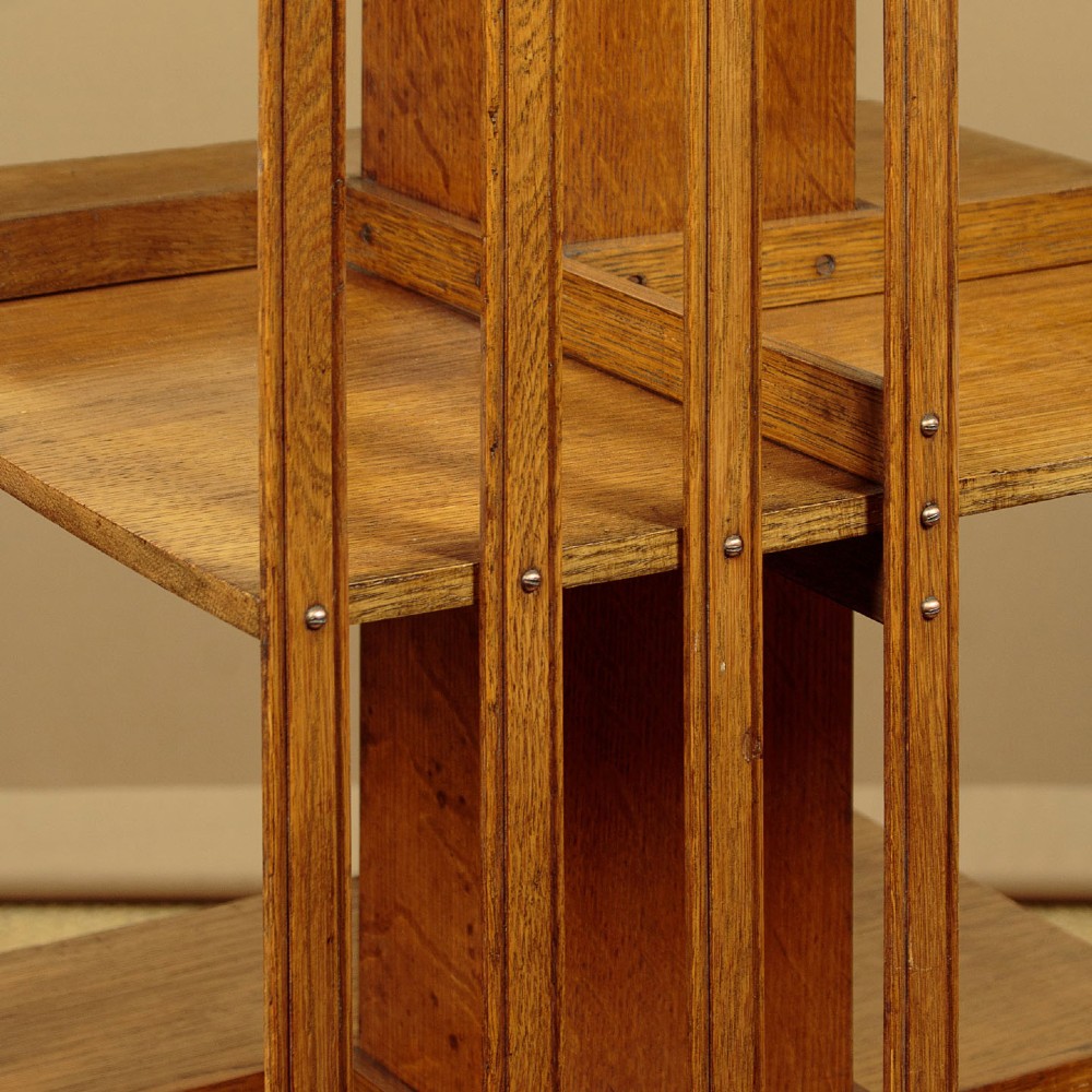 A three-tier Edwardian oak revolving bookcase featuring vertical slatted sides and a square moulded top resting on a rotating cross base. View VI