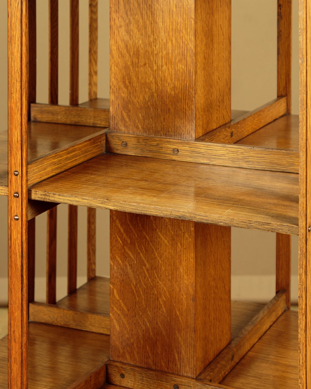 A three-tier Edwardian oak revolving bookcase featuring vertical slatted sides and a square moulded top resting on a rotating cross base. View VII