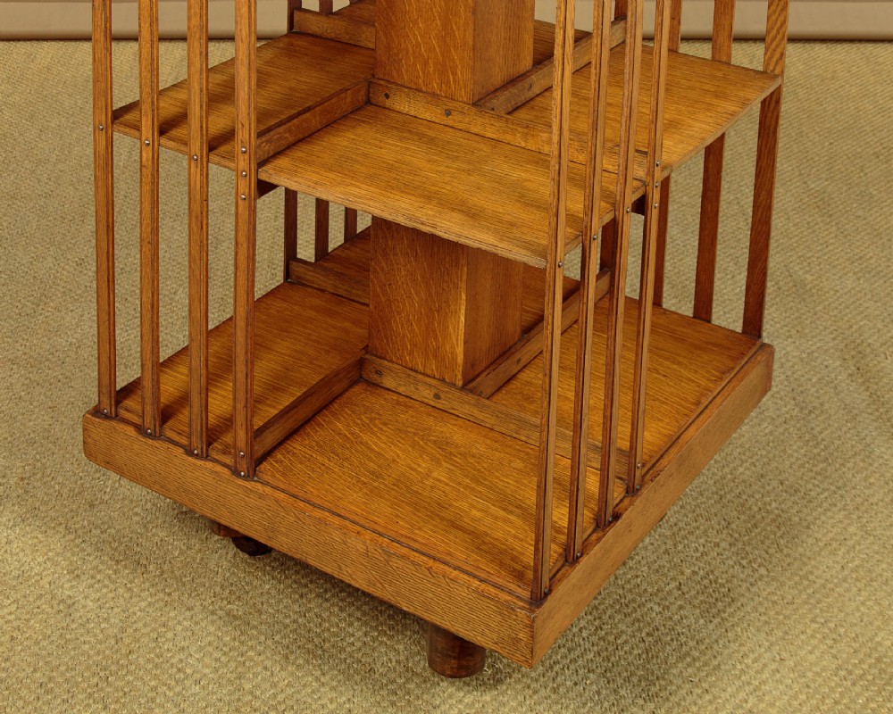 A three-tier Edwardian oak revolving bookcase featuring vertical slatted sides and a square moulded top resting on a rotating cross base. View VIII