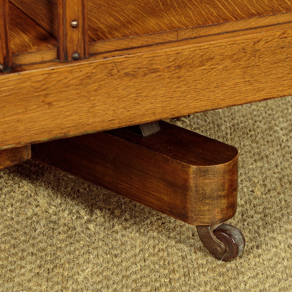 A three-tier Edwardian oak revolving bookcase featuring vertical slatted sides and a square moulded top resting on a rotating cross base. View IX