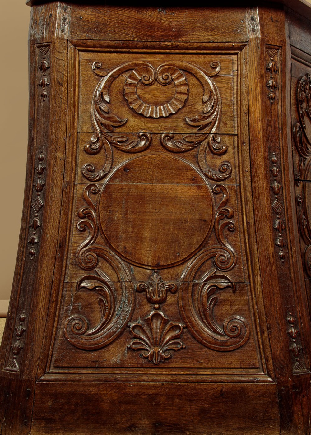 A faceted dark oak pulpit bar featuring carved relief panels with shell motifs and scrollwork. View VII