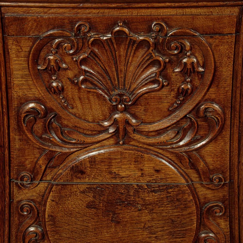 A faceted dark oak pulpit bar featuring carved relief panels with shell motifs and scrollwork. View XI