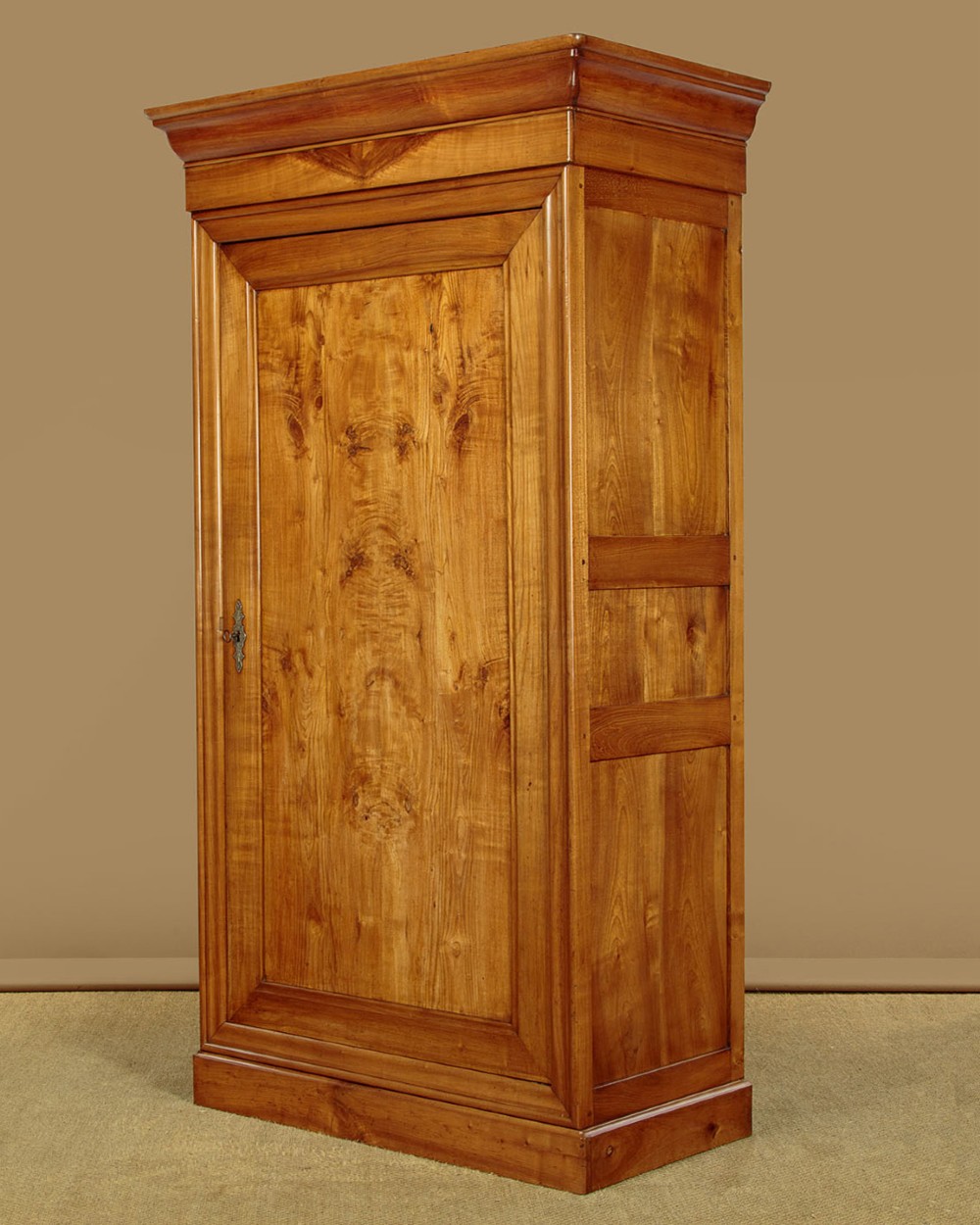 A single-door antique French Louis Philippe cherrywood wardrobe with figured timber grain and a moulded cornice. View III
