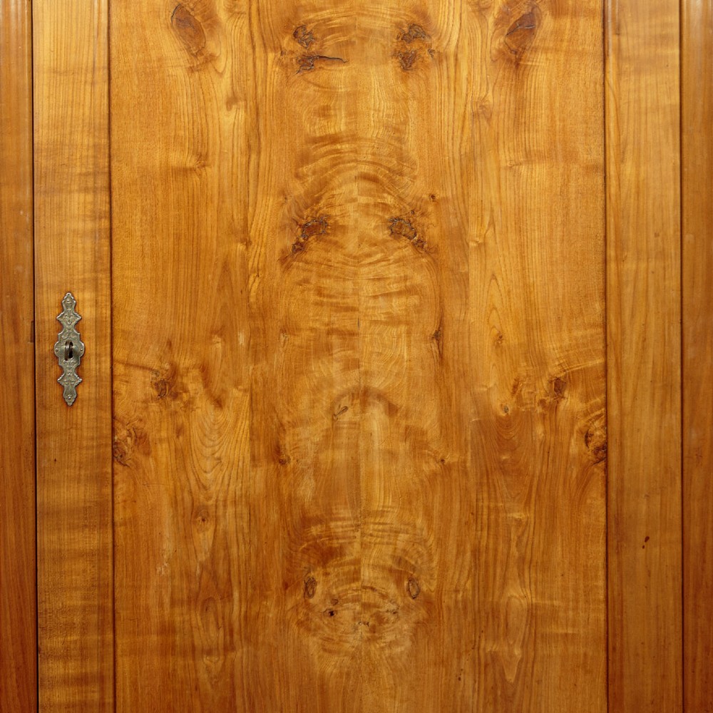 A single-door antique French Louis Philippe cherrywood wardrobe with figured timber grain and a moulded cornice. View VII