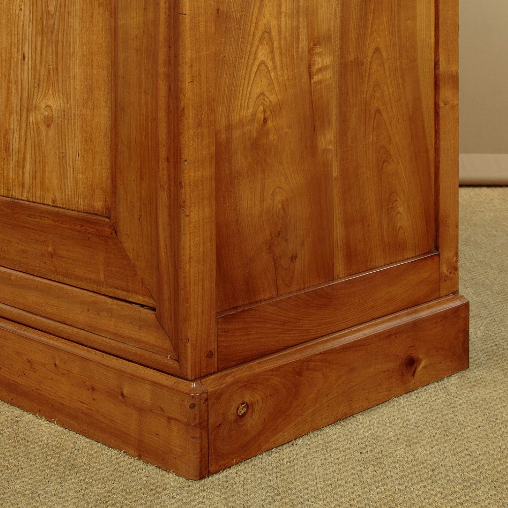 A single-door antique French Louis Philippe cherrywood wardrobe with figured timber grain and a moulded cornice. View X