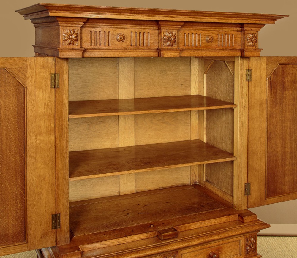 A warm brown oak cabinet featuring arched doors set upon a matching stand with large turned bulbous legs and lower stretchers. View VIII