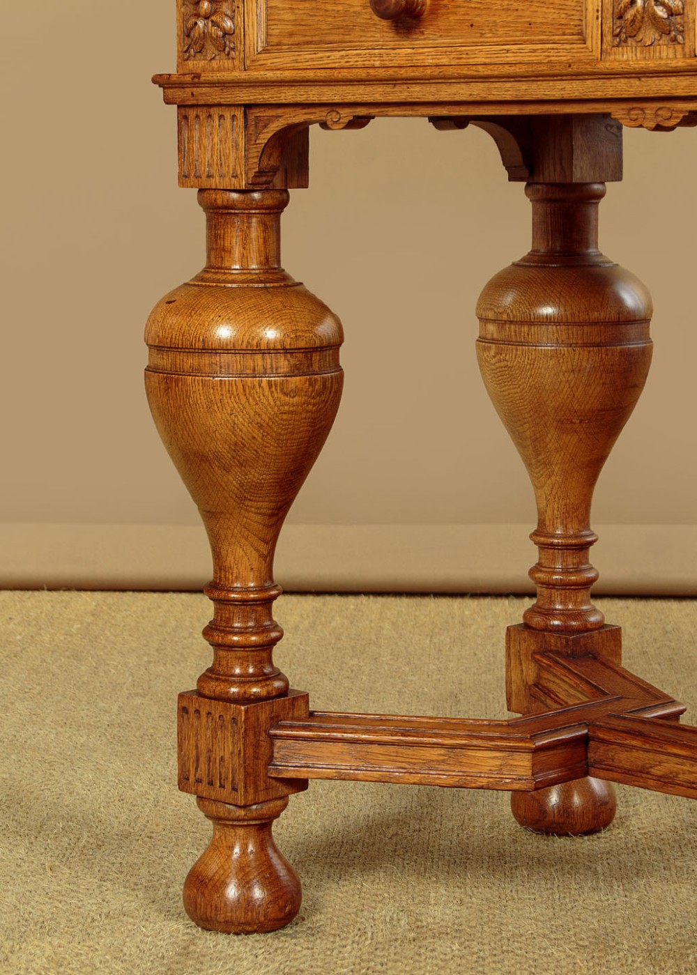 A warm brown oak cabinet featuring arched doors set upon a matching stand with large turned bulbous legs and lower stretchers. View XI