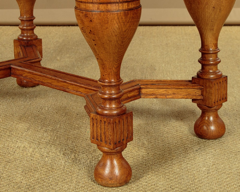 A warm brown oak cabinet featuring arched doors set upon a matching stand with large turned bulbous legs and lower stretchers. View XII
