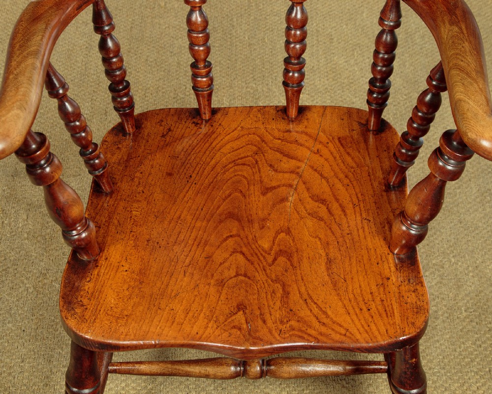 A Victorian smokers bow wooden armchair with turned spindles, a curved top rail, a contoured elm seat, and turned legs. View VIII