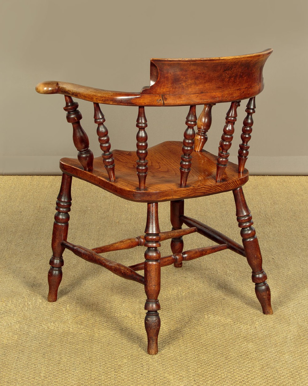 A Victorian smokers bow wooden armchair with turned spindles, a curved top rail, a contoured elm seat, and turned legs. View XI