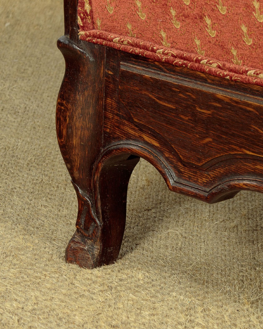 A c.1920 French-style upholstered day bed featuring a dark carved wooden frame, terracotta red patterned fabric, and matching tassel-trimmed cushions. View XV