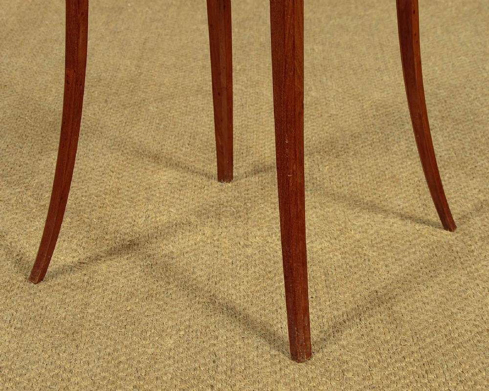 A tall, slender Edwardian specimen wood plant stand featuring geometric marquetry inlay on the top, apron, and legs, supported by four gently sweeping legs joined by an inlaid cross-stretcher. View VII