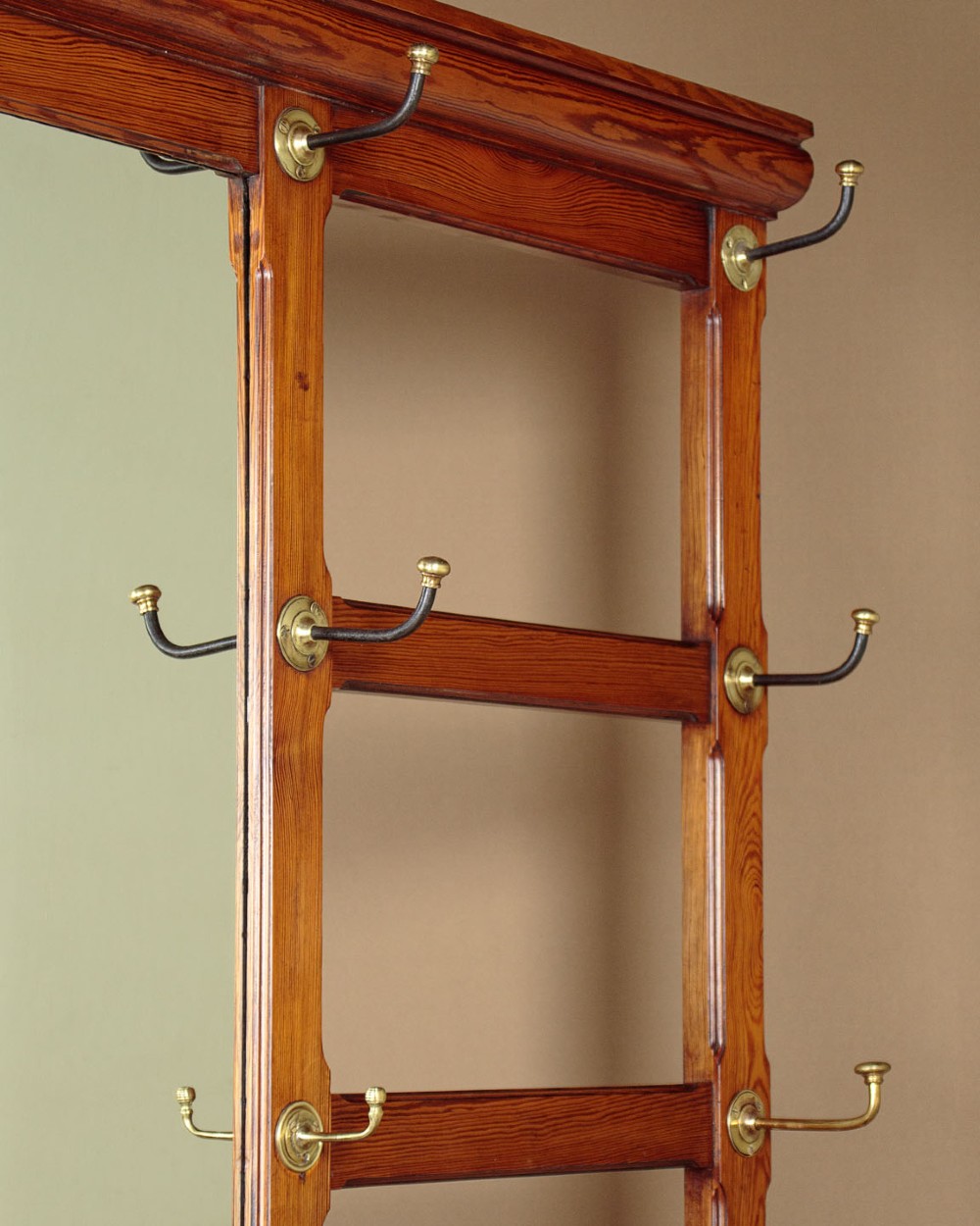 A large Victorian pine hallstand featuring a central vertical mirror, multiple brass coat hooks, inset ceramic tiles, a marble-topped glove drawer, and lower umbrella stand trays. View V