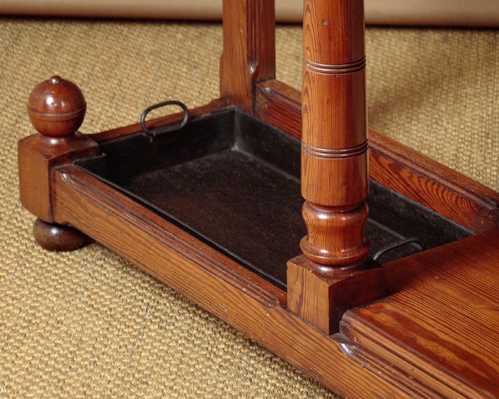 A large Victorian pine hallstand featuring a central vertical mirror, multiple brass coat hooks, inset ceramic tiles, a marble-topped glove drawer, and lower umbrella stand trays. View XII