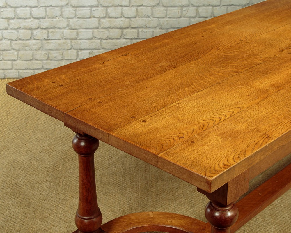 A long solid oak refectory dining table featuring turned legs and a low curved stretcher base. View VI