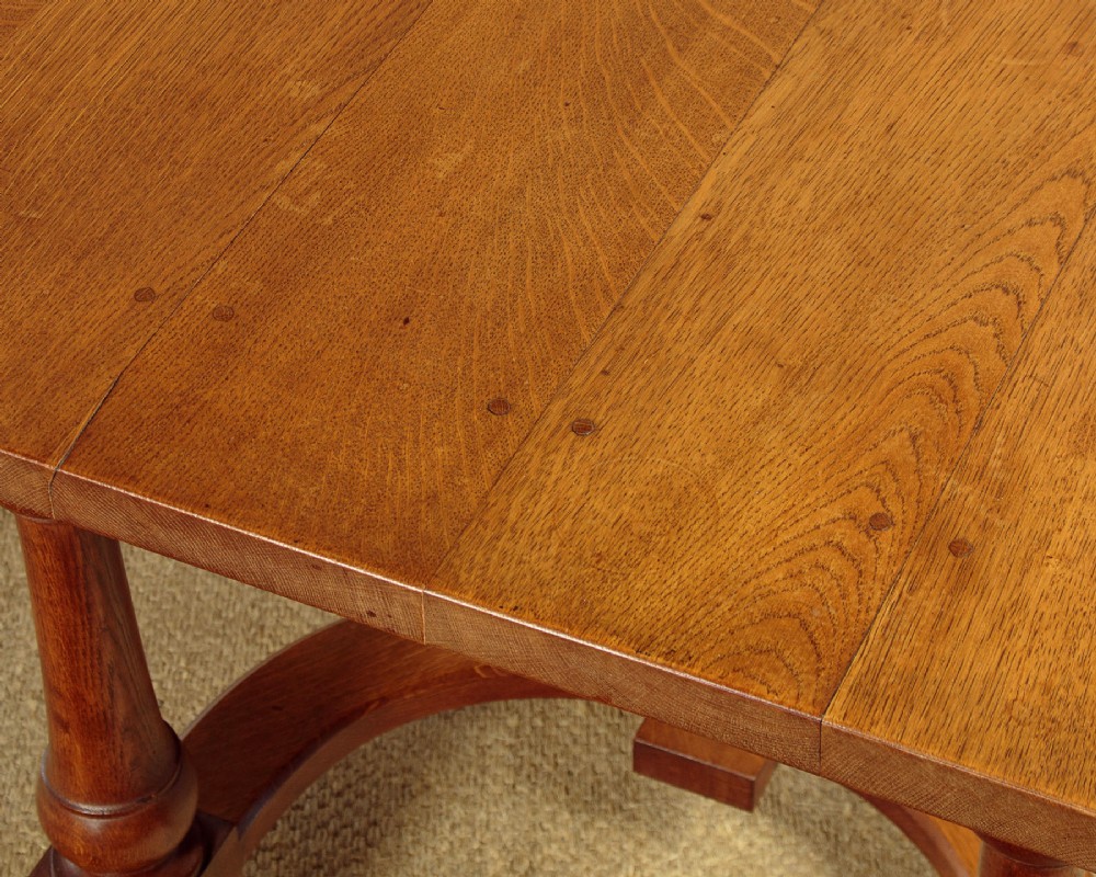 A long solid oak refectory dining table featuring turned legs and a low curved stretcher base. View VIII