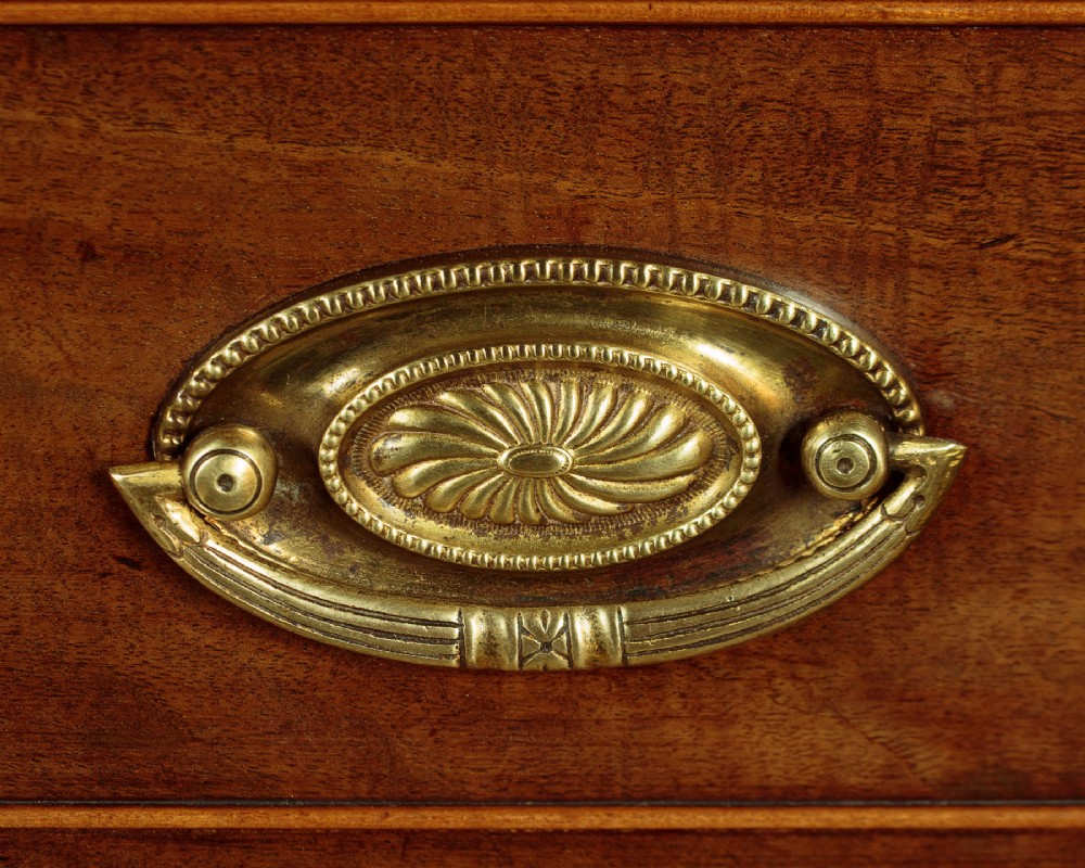 A tall mahogany secretaire bureau bookcase featuring two upper glazed doors with geometric astragal glazing over a chest of drawers with brass oval handles. View XI