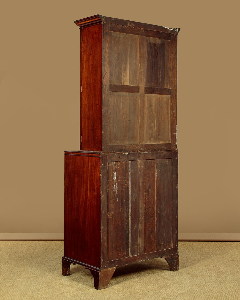 A tall mahogany secretaire bureau bookcase featuring two upper glazed doors with geometric astragal glazing over a chest of drawers with brass oval handles. View XIII