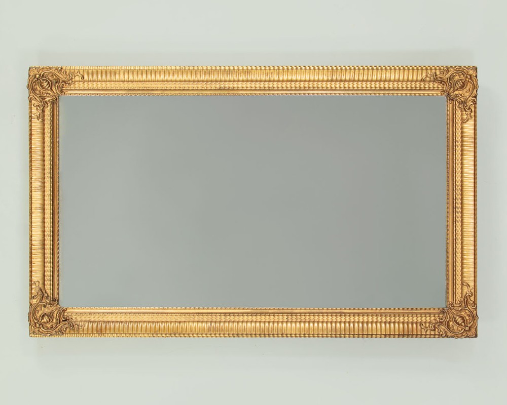 A rectangular wall mirror featuring a gilded frame with reeded moulding and carved scrollwork details in each corner. View II