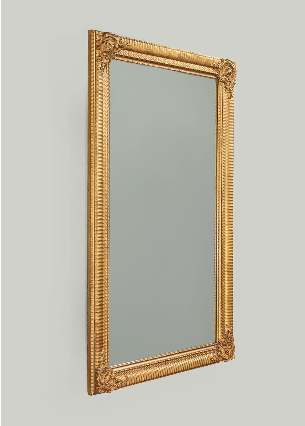 A rectangular wall mirror featuring a gilded frame with reeded moulding and carved scrollwork details in each corner. View III