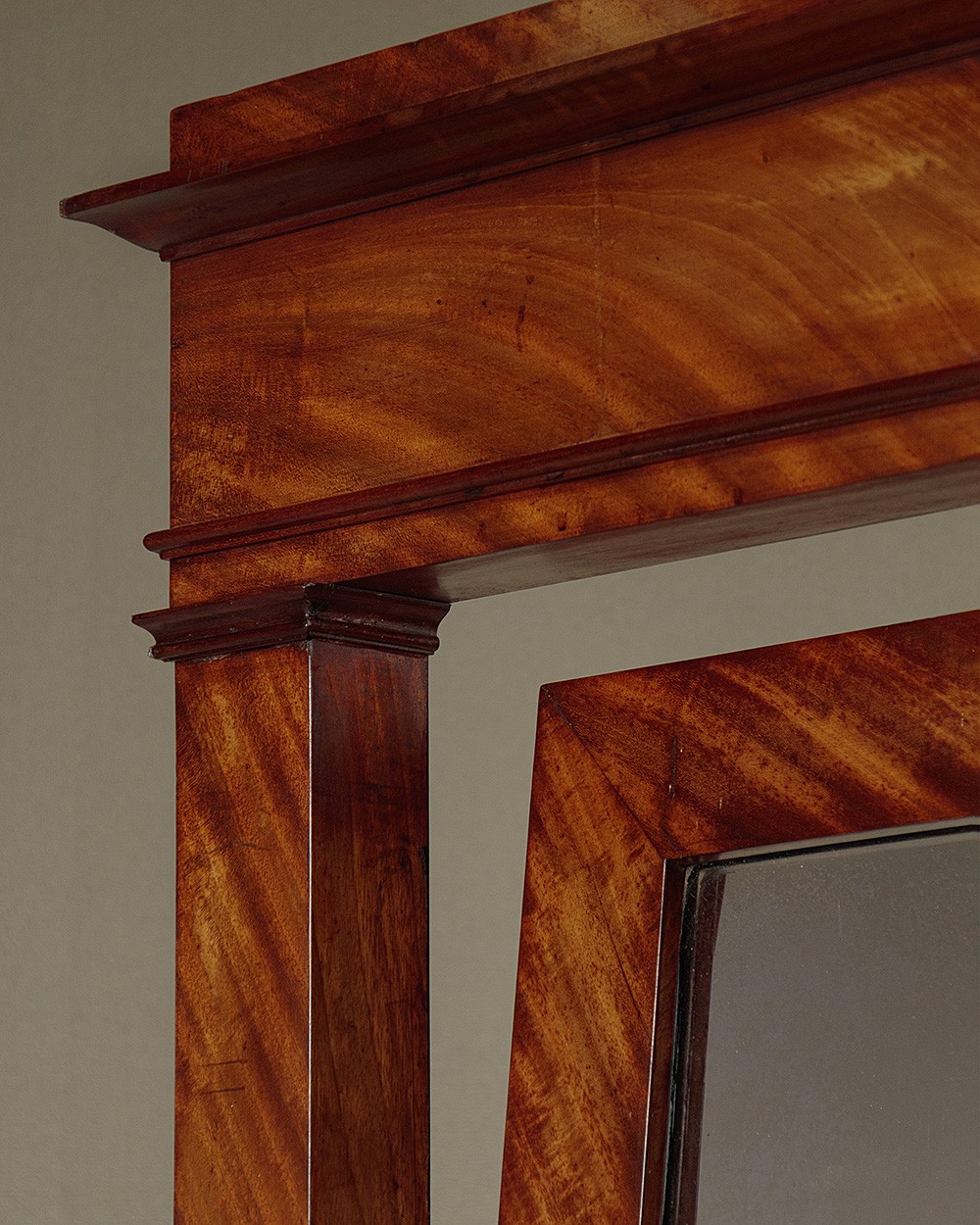 A mid-19th-century mahogany cheval mirror featuring a rectangular swivelling frame set between upright supports with an architectural corniced top and brass mount, resting on splayed feet with castors. View III