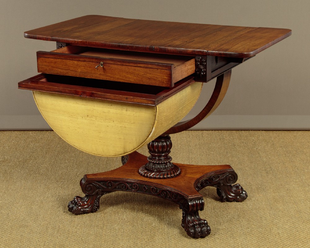 A nineteenth-century rosewood Pembroke side table with drop-leaf sides, a fabric work basket, turned column, and carved scroll feet. View III