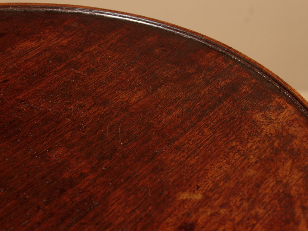A two-tiered Georgian mahogany dumb waiter with turned baluster columns and a tripod base on brass castors. View IV