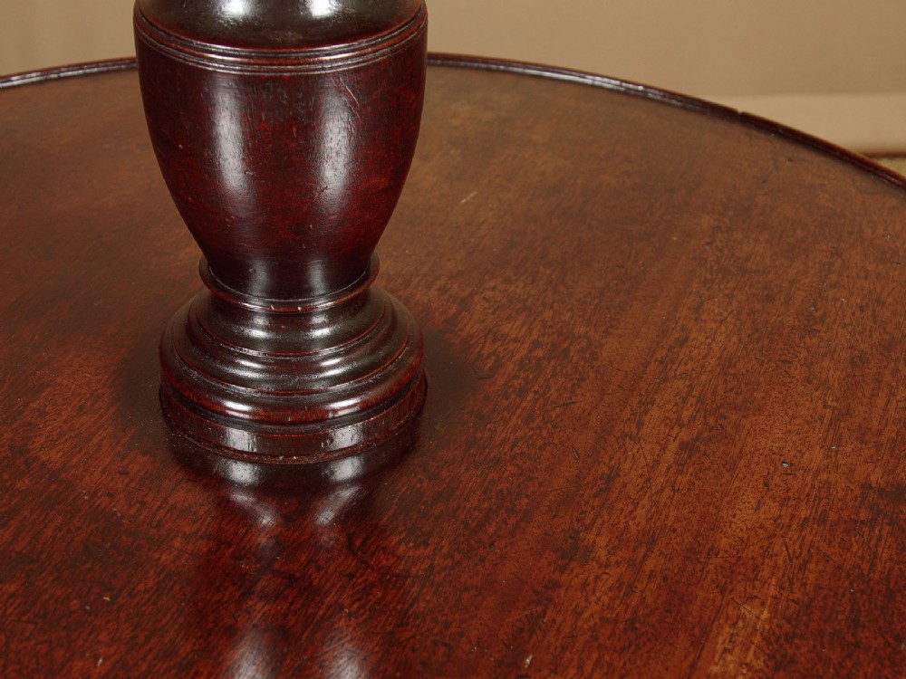 A two-tiered Georgian mahogany dumb waiter with turned baluster columns and a tripod base on brass castors. View VIII