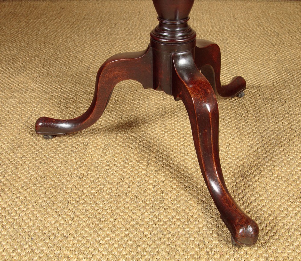 A two-tiered Georgian mahogany dumb waiter with turned baluster columns and a tripod base on brass castors. View IX