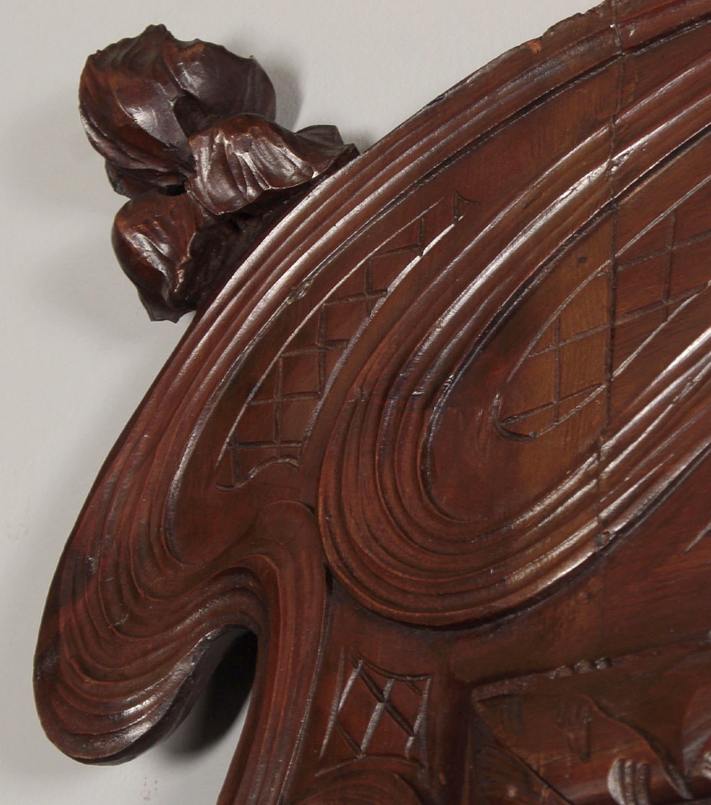 An antique Art Nouveau wall mirror featuring an intricately carved dark wood frame with sweeping whiplash curves and floral accents surrounding rectangular mirror glass. View V