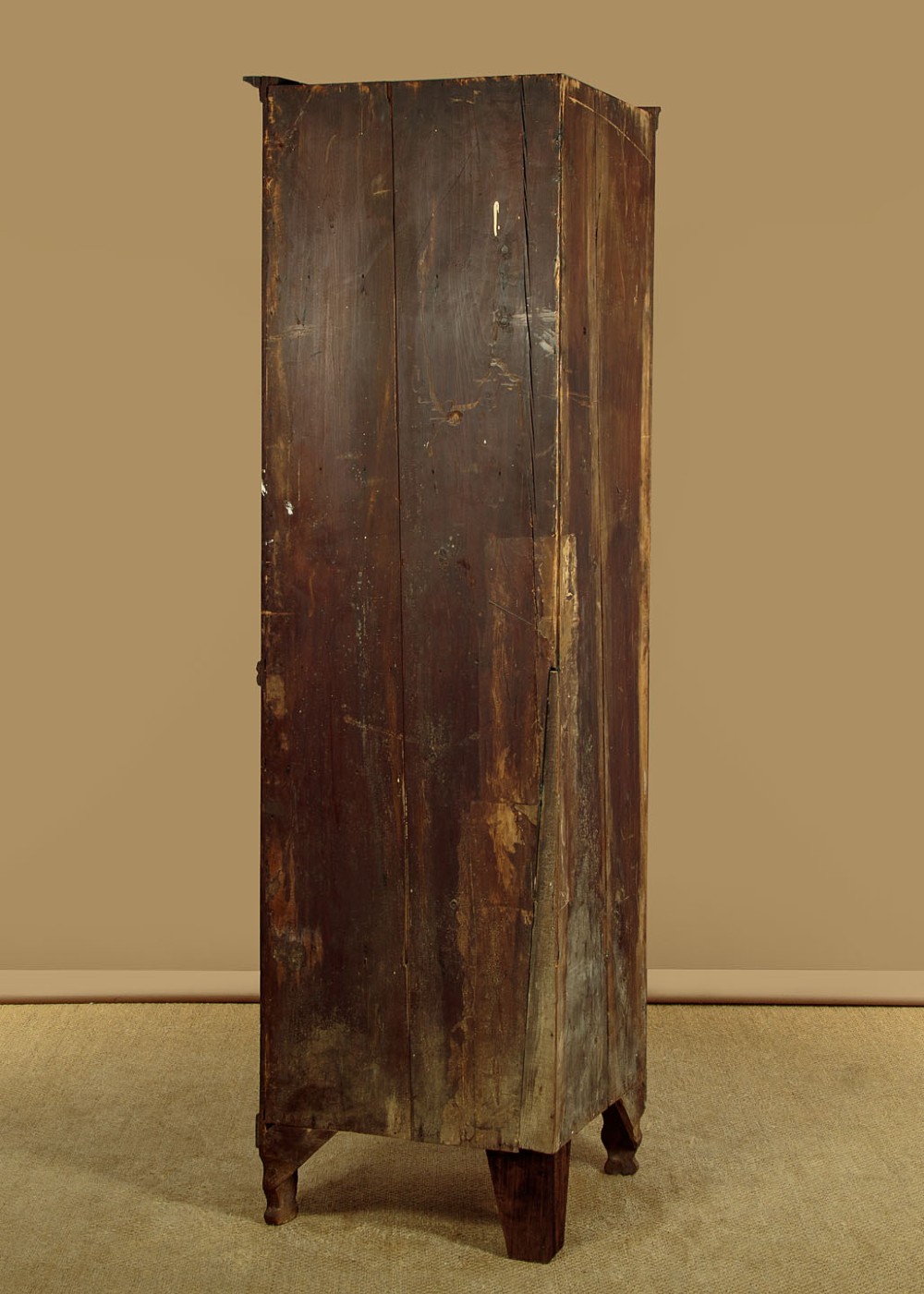 A tall early 19th-century dark mahogany double height corner cupboard featuring reeded front doors, a central drawer, and Gothic arcading at the cornice. View XI
