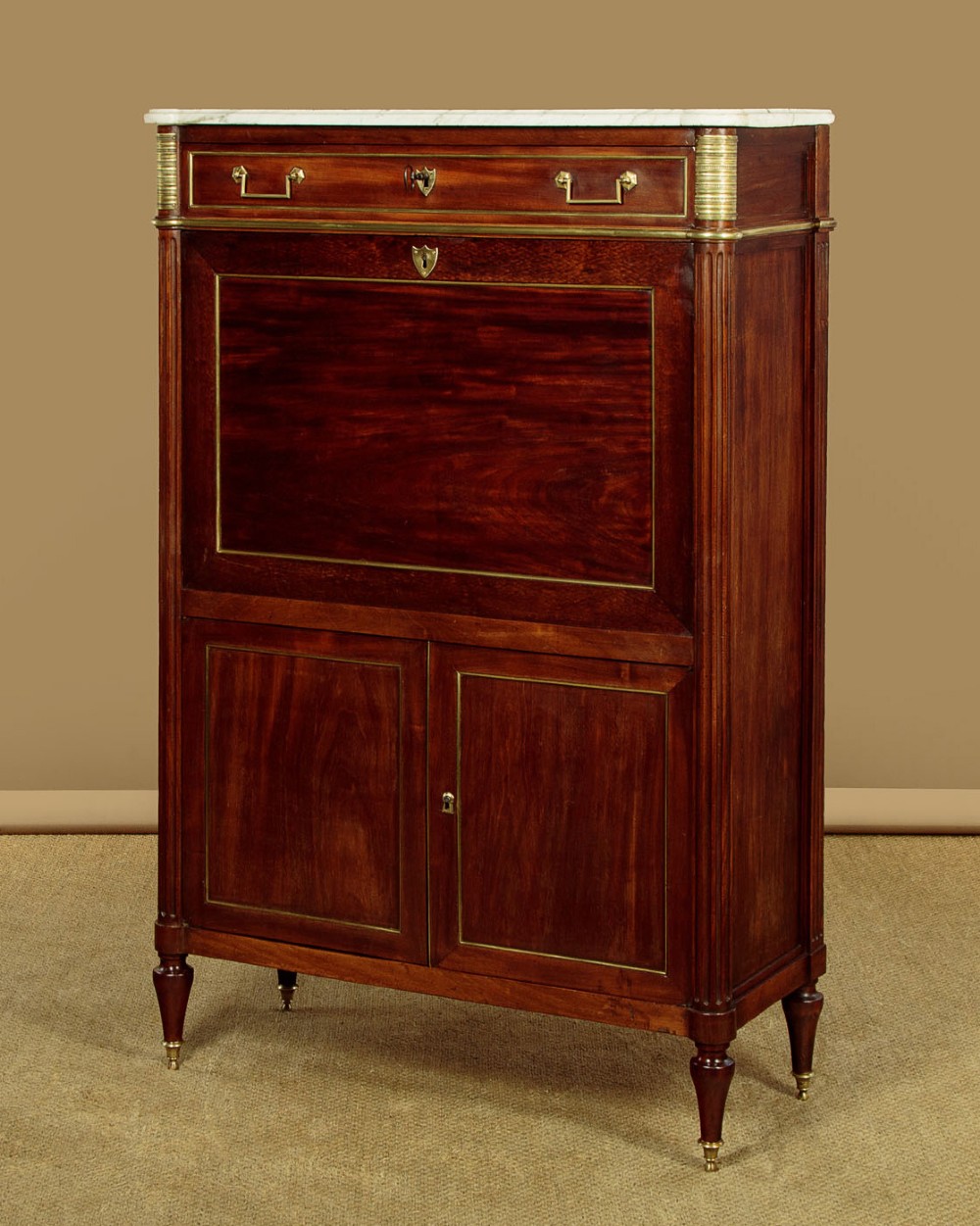 An 1830 mahogany secretaire abattant featuring a white marble top, brass-mounted fluted side columns, a drop-front writing panel, and a double-door cupboard. View IV