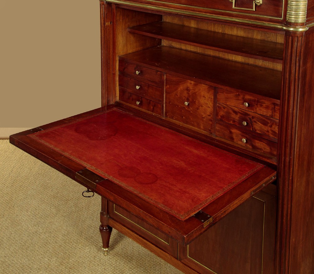 An 1830 mahogany secretaire abattant featuring a white marble top, brass-mounted fluted side columns, a drop-front writing panel, and a double-door cupboard. View VII