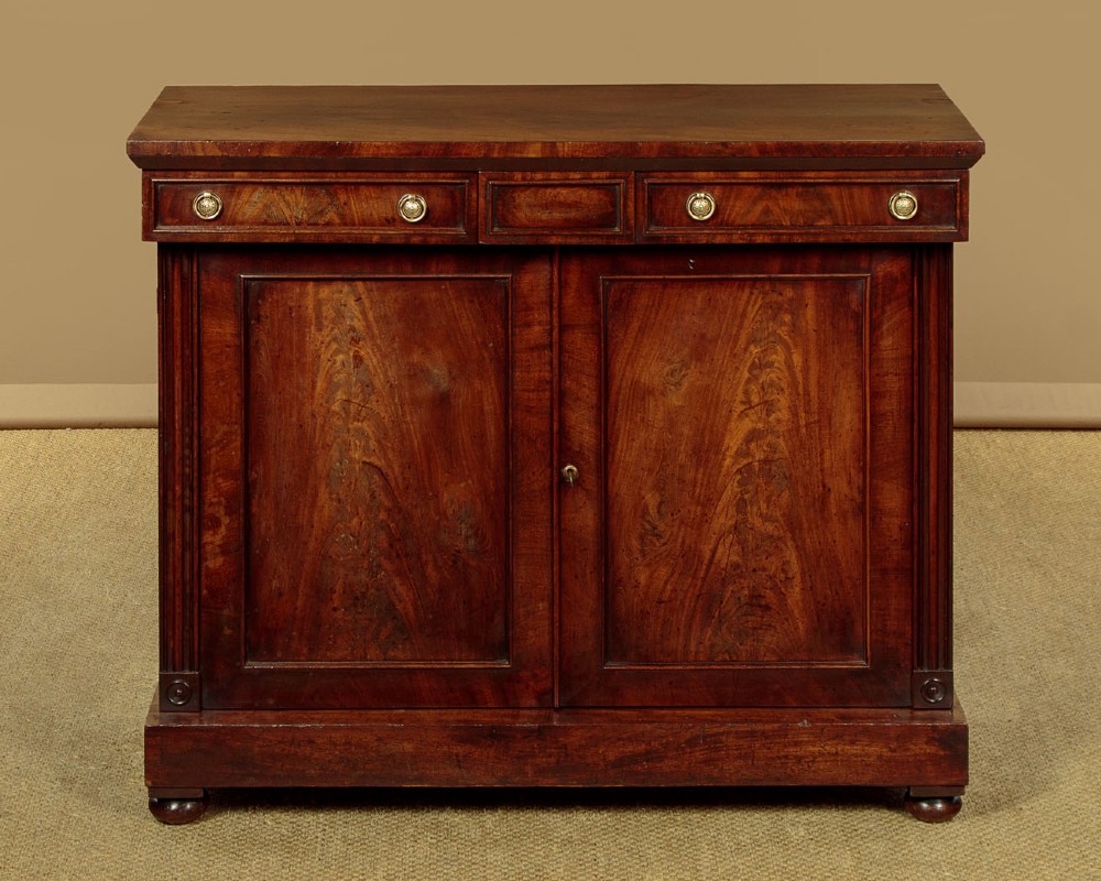 A Victorian flame mahogany chiffonier cabinet featuring frieze drawers with brass ring pulls and twin panelled cupboard doors on a plinth base.