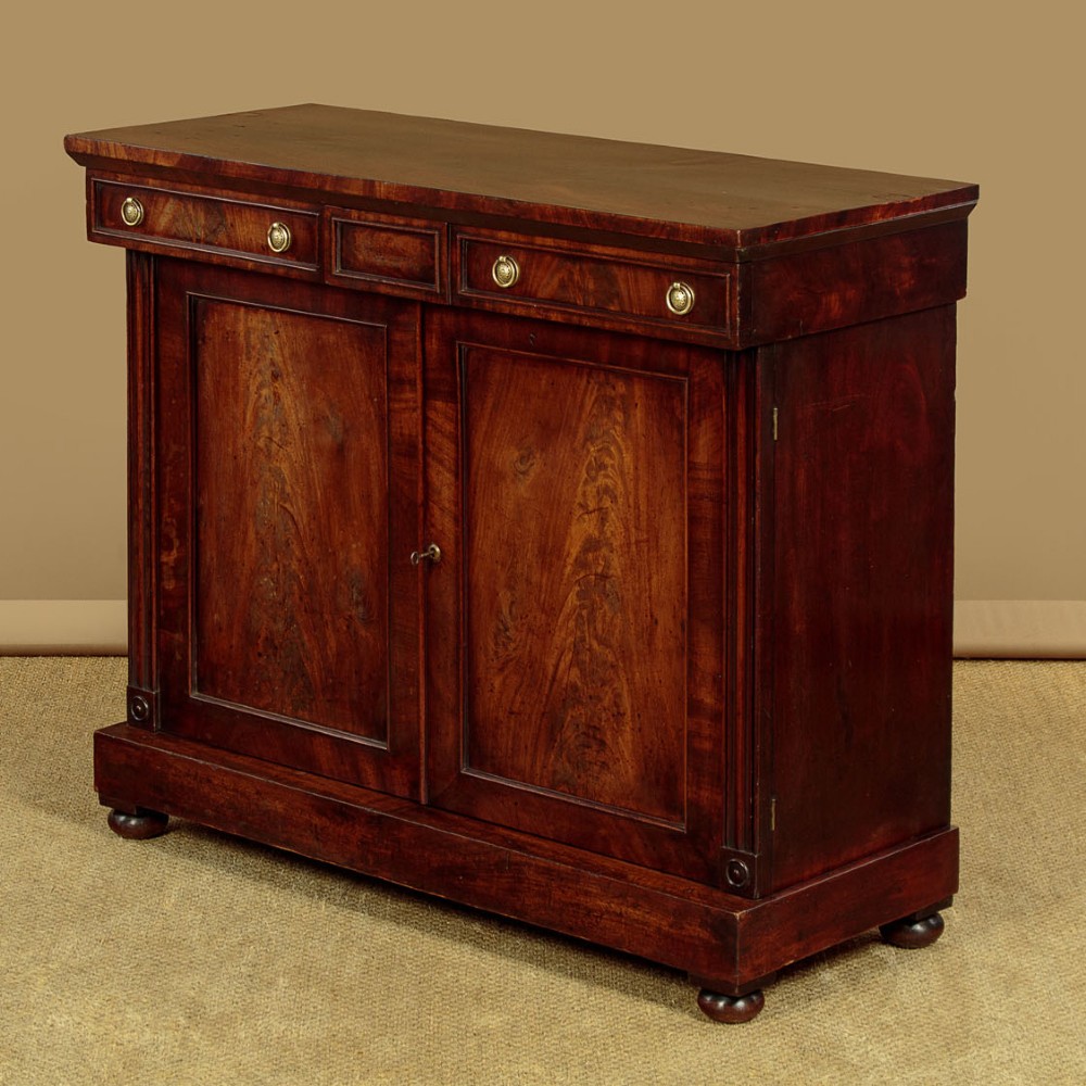 A Victorian flame mahogany chiffonier cabinet featuring frieze drawers with brass ring pulls and twin panelled cupboard doors on a plinth base. View III