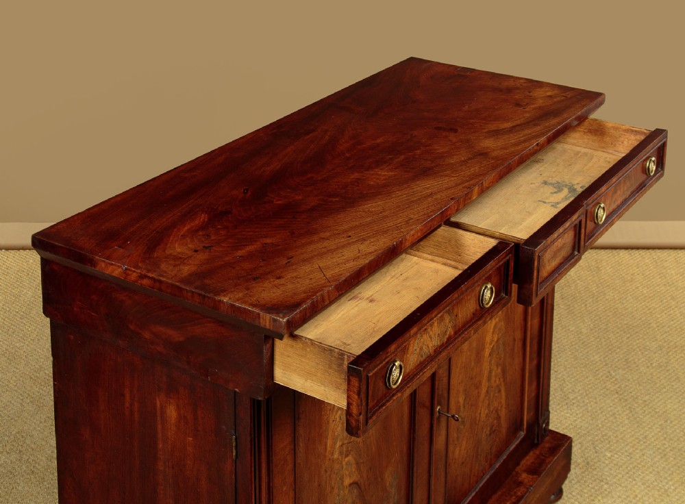 A Victorian flame mahogany chiffonier cabinet featuring frieze drawers with brass ring pulls and twin panelled cupboard doors on a plinth base. View VII