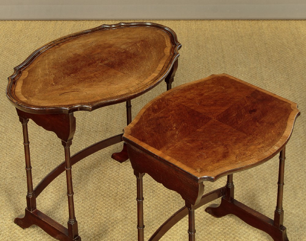 A set of four graduated dark mahogany quartetto nesting tables featuring turned spindle legs and shaped tops. View VI