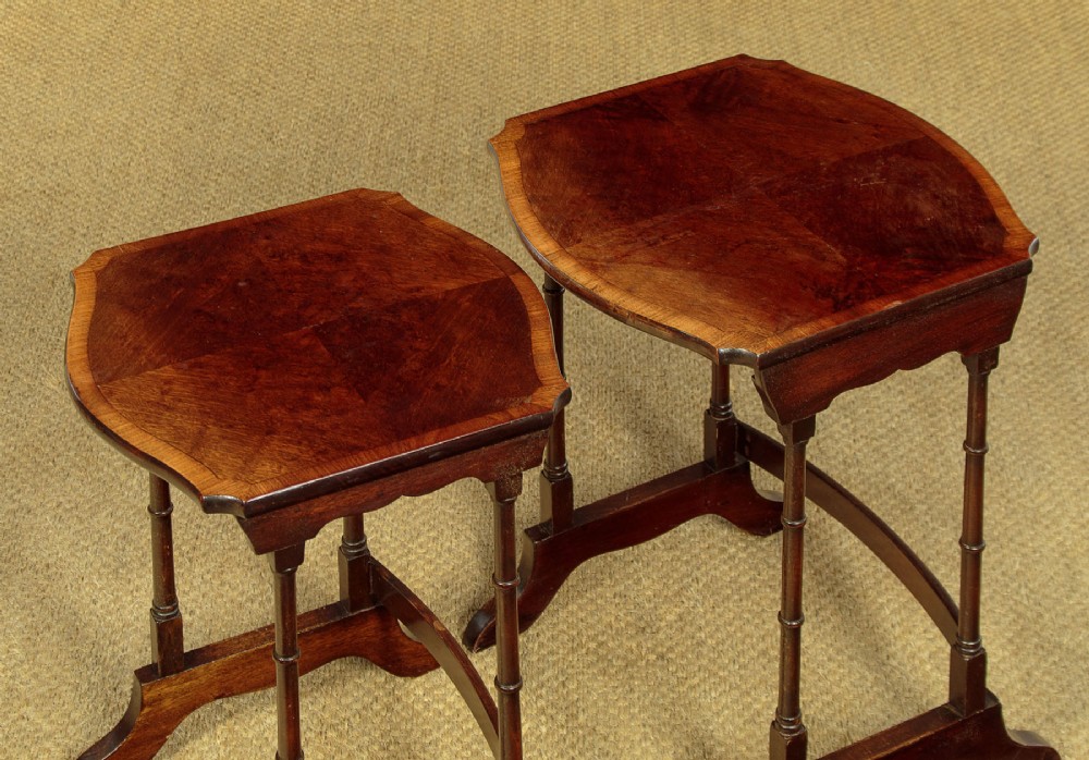 A set of four graduated dark mahogany quartetto nesting tables featuring turned spindle legs and shaped tops. View VII