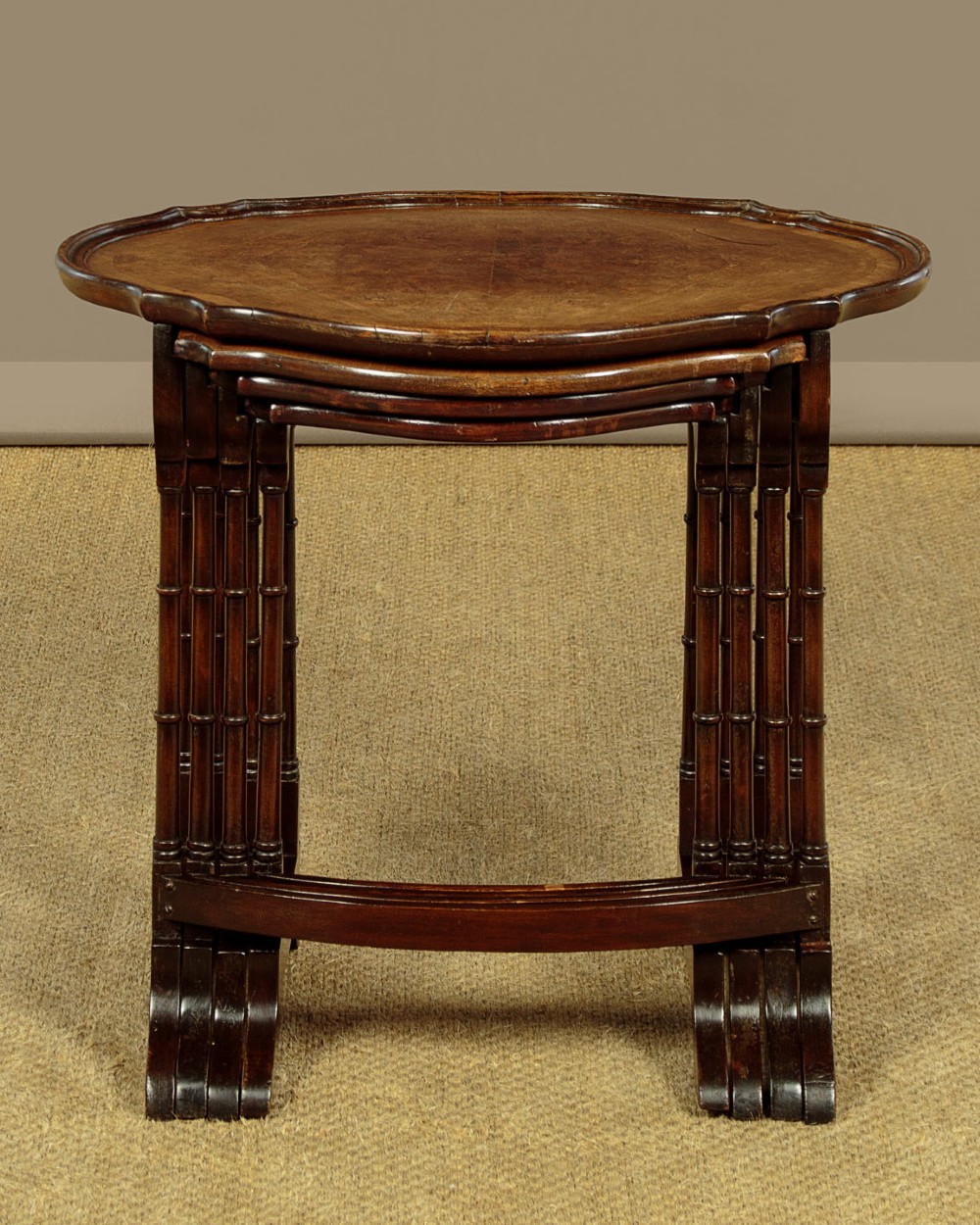 A set of four graduated dark mahogany quartetto nesting tables featuring turned spindle legs and shaped tops. View IX