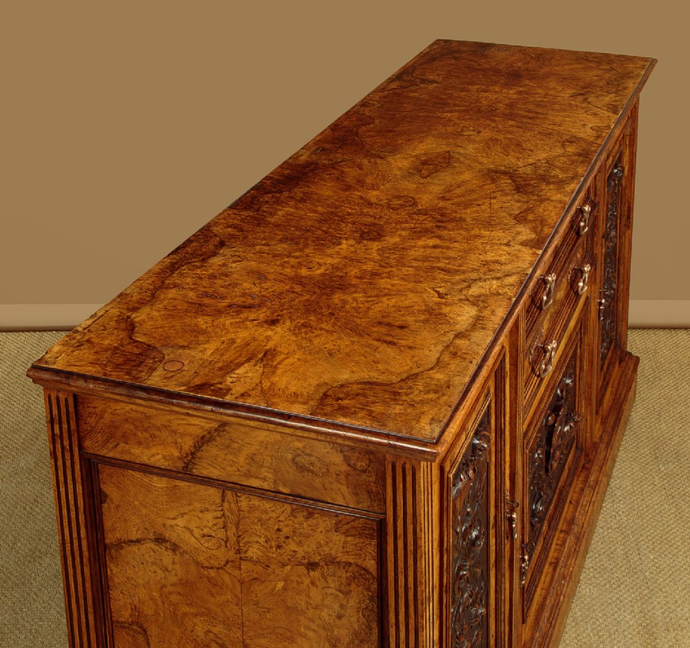 A late Victorian pollard oak sideboard featuring relief-carved panel doors, two central drawers with brass handles, and a continuous plinth base. View VI