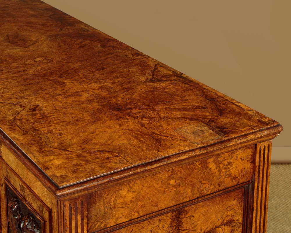 A late Victorian pollard oak sideboard featuring relief-carved panel doors, two central drawers with brass handles, and a continuous plinth base. View VII