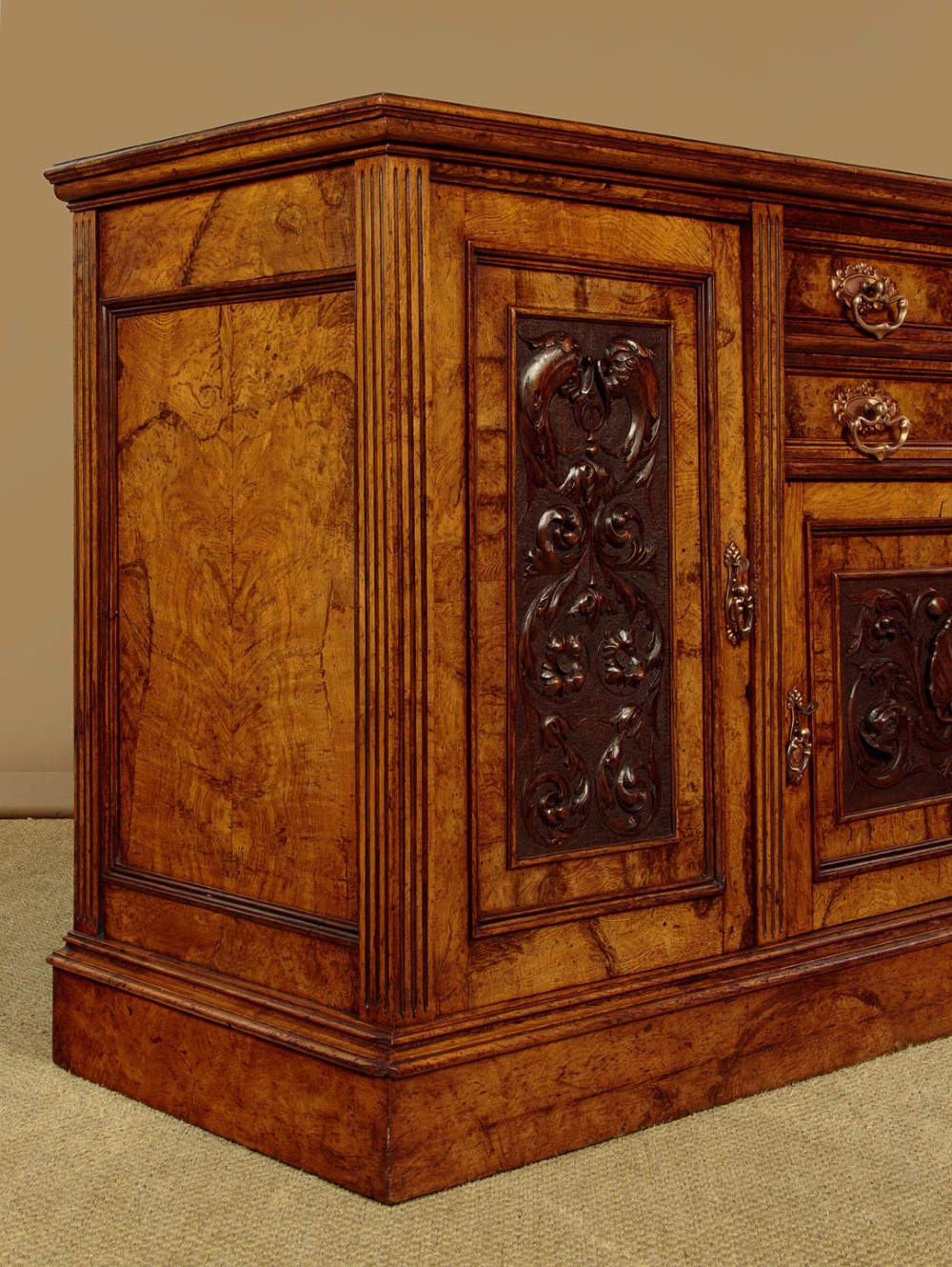 A late Victorian pollard oak sideboard featuring relief-carved panel doors, two central drawers with brass handles, and a continuous plinth base. View XI